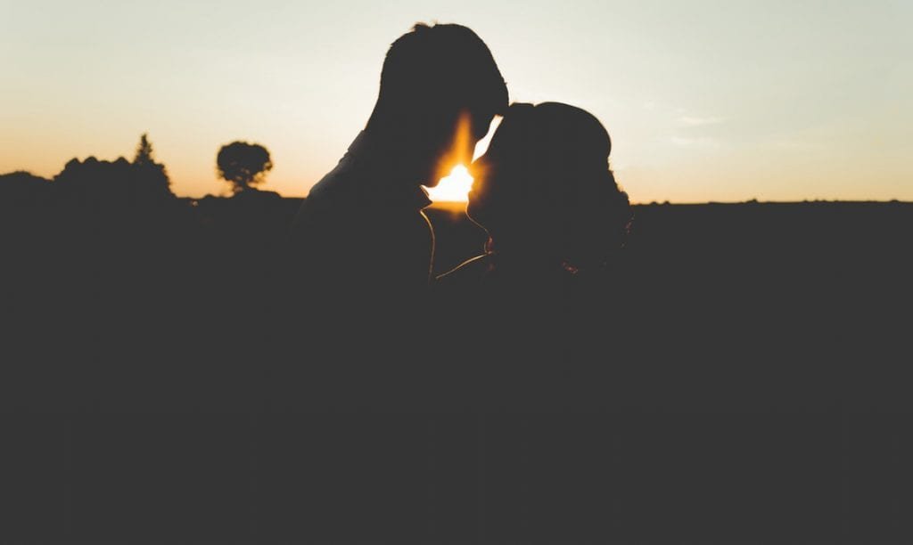 sexo pós-parto - foto de um casal a beijar-se ao pôr do sol- Foto Unsplash